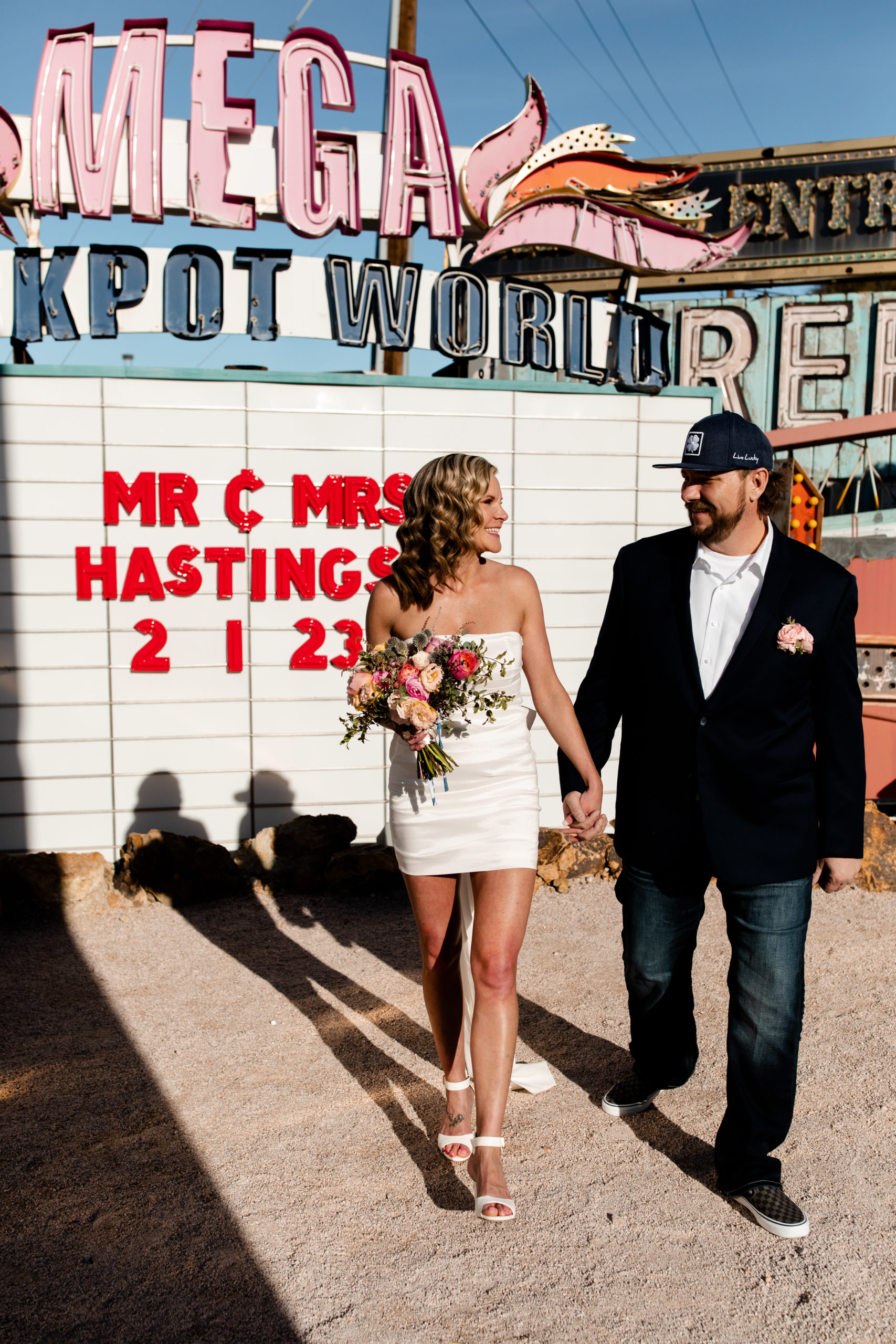 A bride and groom eloping at the Neon Museum in front of a personalized marquee sign.