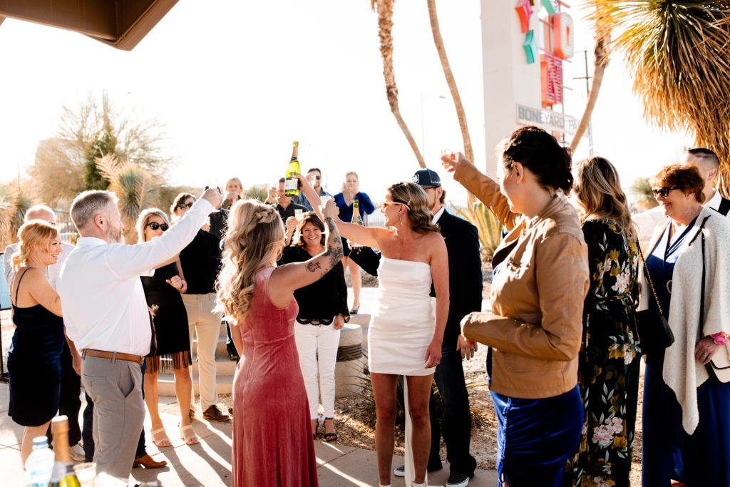 A bride and groom celebrating with a champagne toast with all of their elopement guests
