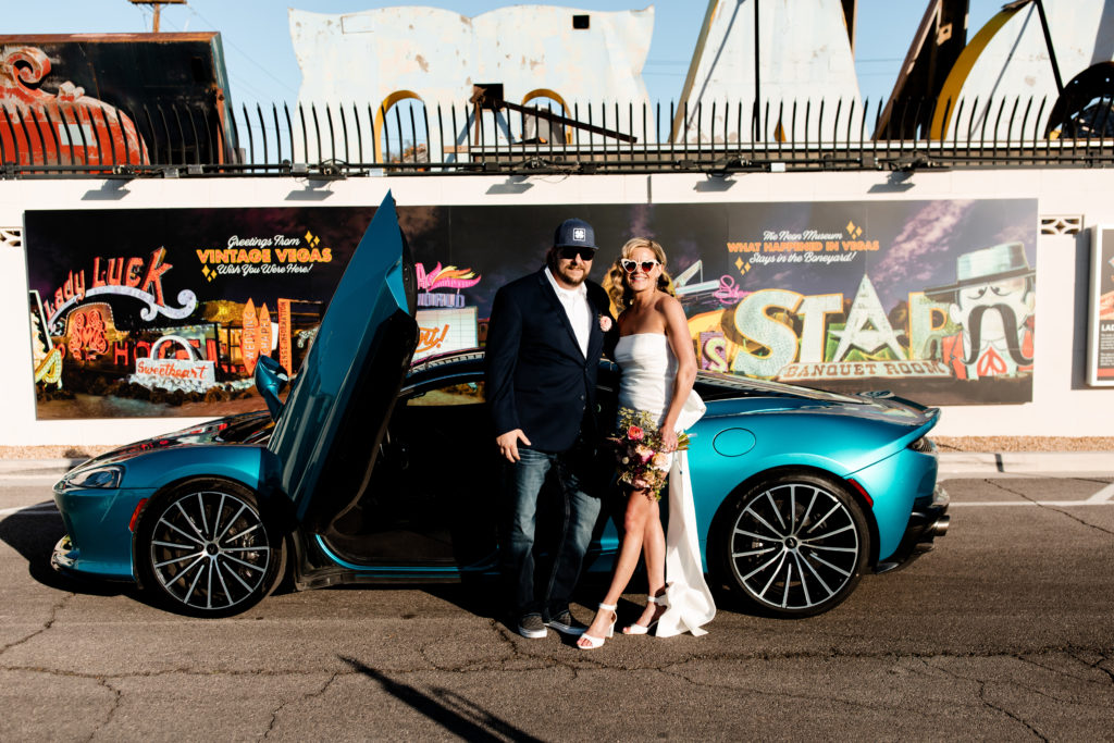 A bride and groom with their McLaren at the Neon Museum