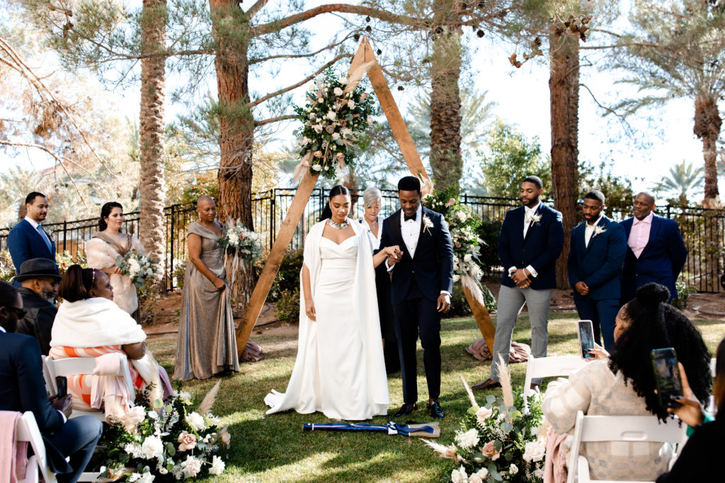 Bride and groom jumping the broom at their wedding ceremony.