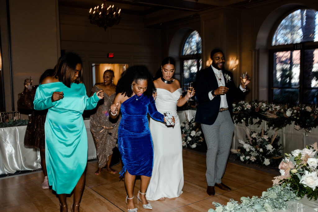 Bride dancing with all of her friends at their wedding reception