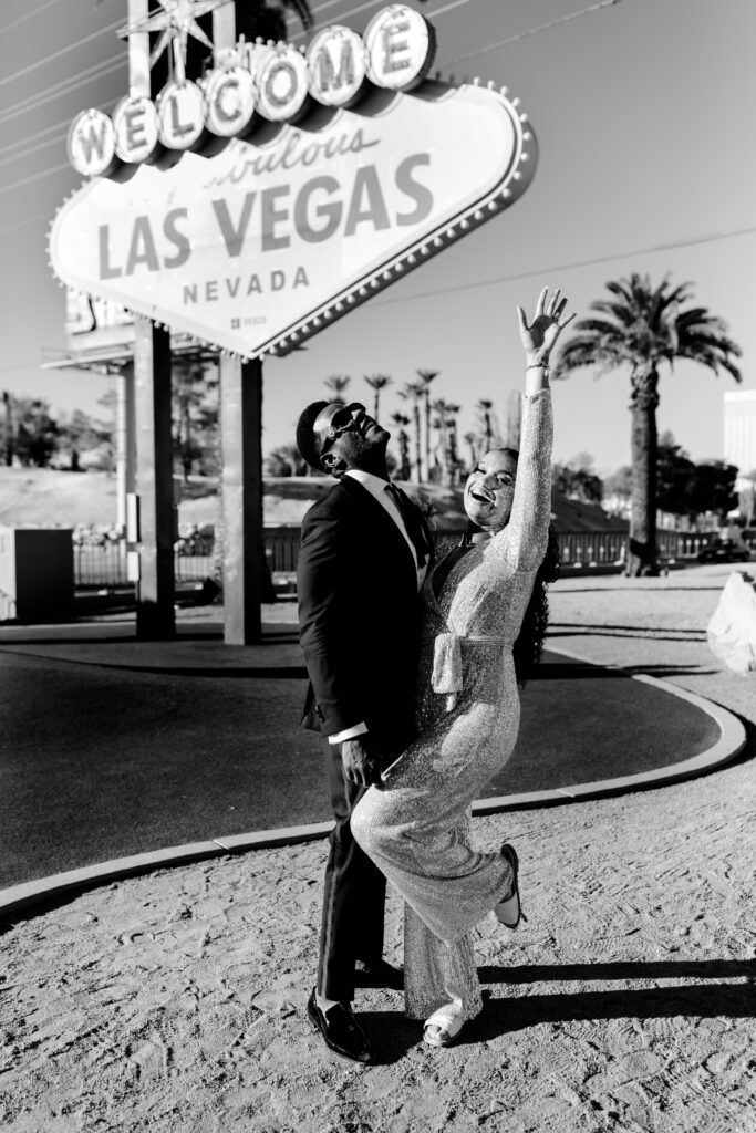 Bride and groom celebrating their wedding at the Welcome to Las Vegas sign