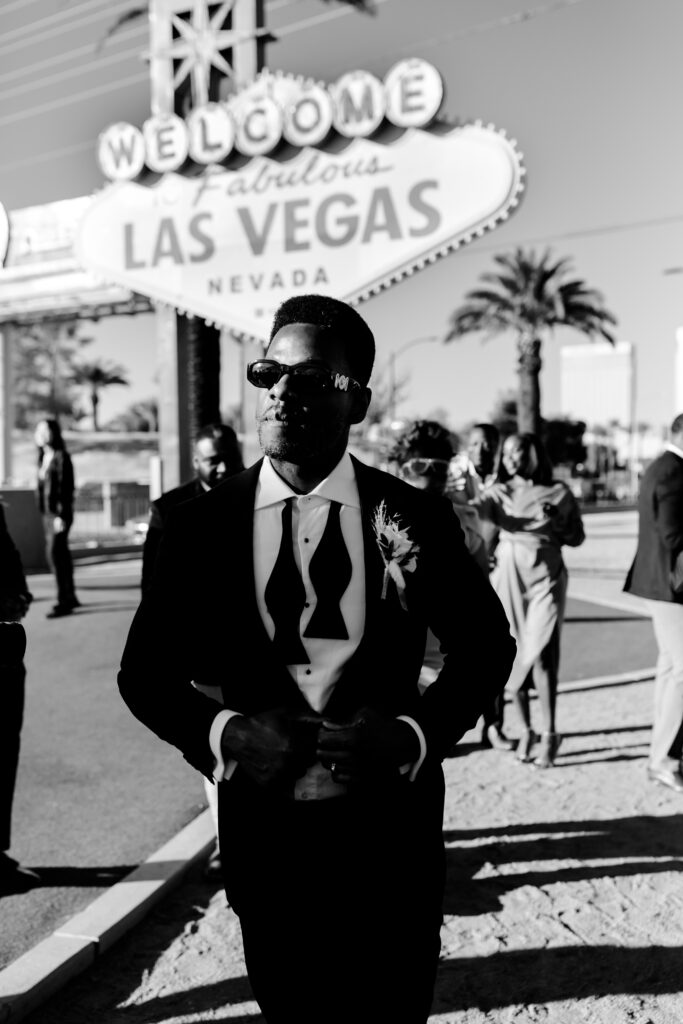Groom in classic tuxedo at the Welcome to Las Vegas sign