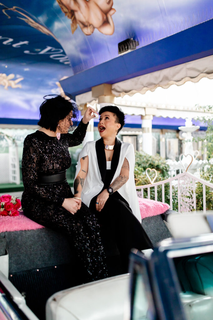 Brides sharing a candid moment of laughter outside A Little White Chapel, Las Vegas