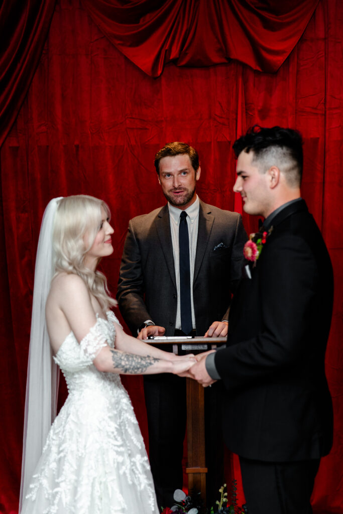 The bride and groom exchange heartfelt vows surrounded by punk rock memorabilia at the Punk Rock Museum, creating a unique and memorable ceremony.