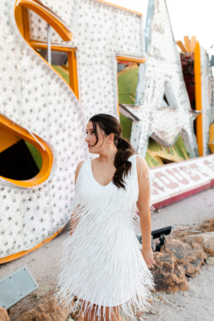 bride's portrait in Neon Museum setting in a short white sequin fringe dress