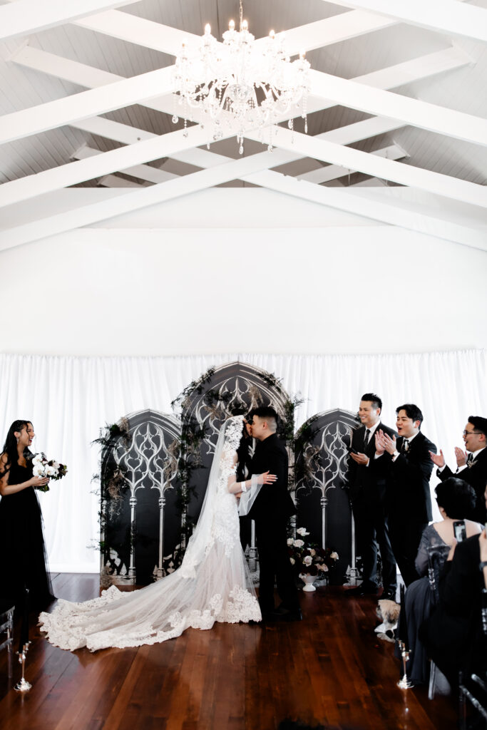 The newlyweds share their first kiss at the Sonic Temple, with colorful lighting and artistic elements enhancing the moment.