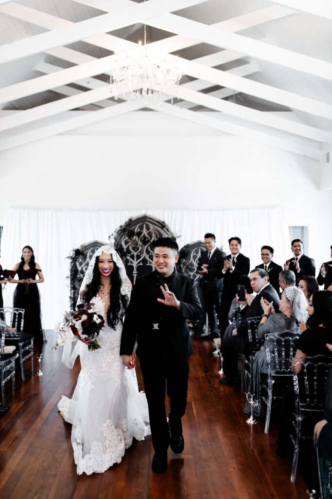 Las Vegas wedding photographer captures The bride and groom walk out of the Sonic Temple after their ceremony, beaming with happiness as guests shower them with applause.