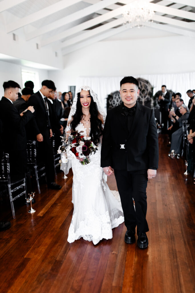 The newlyweds make a joyful exit from the Sonic Temple, holding hands and smiling brightly as they are celebrated by their loved ones.