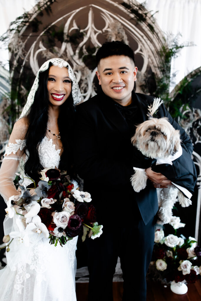 Las Vegas wedding photographer captures The bride and groom pose with their beloved dog at the Sonic Temple, capturing a heartwarming family moment on their special day.