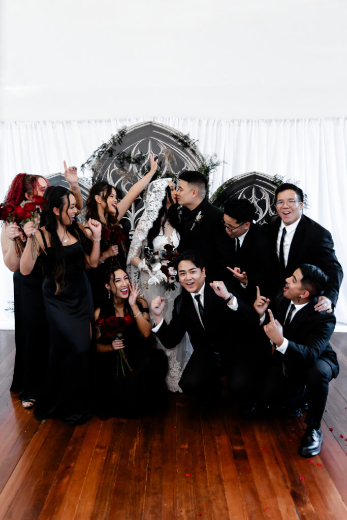 The wedding party poses together at the Sonic Temple, each member showcasing the gothic theme of the wedding.