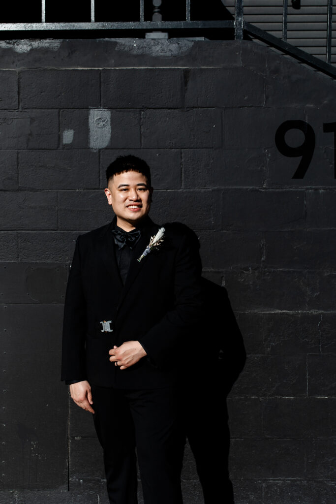 A striking portrait of the groom at the Sonic Temple, highlighting his confident and stylish look in the gothic setting.