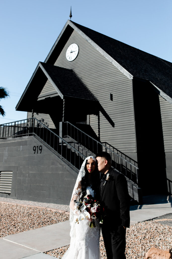 The bride and groom pose for a portrait at the Sonic Temple, with the venue's artistic and gothic backdrop adding to the beauty.