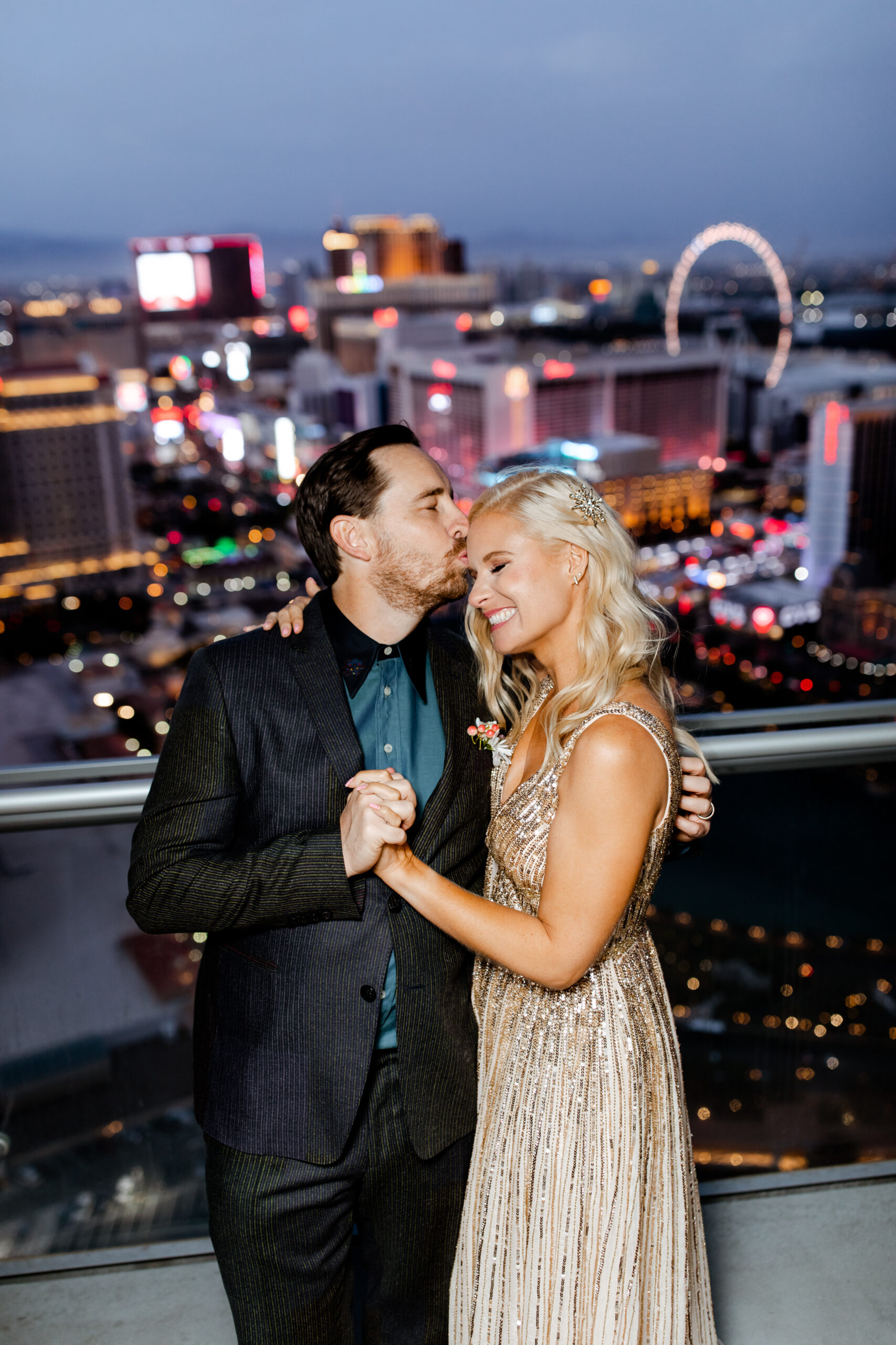 The bride and groom exchange vows during a sunset ceremony on the balcony, with the Las Vegas Strip as a breathtaking backdrop.