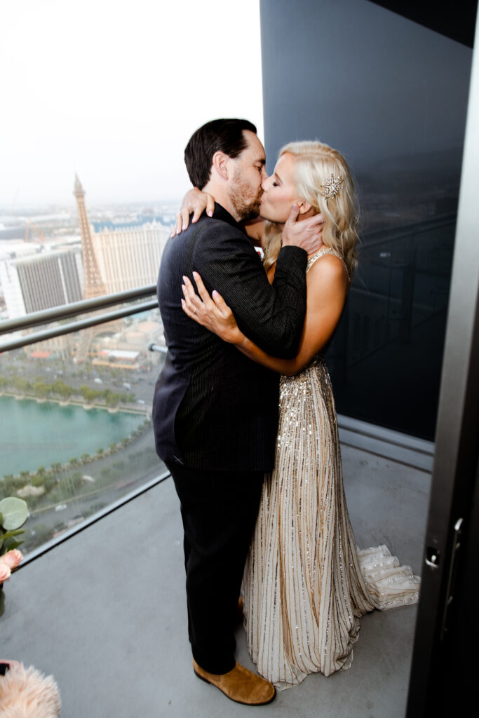 The newlyweds share a celebratory kiss on the balcony.