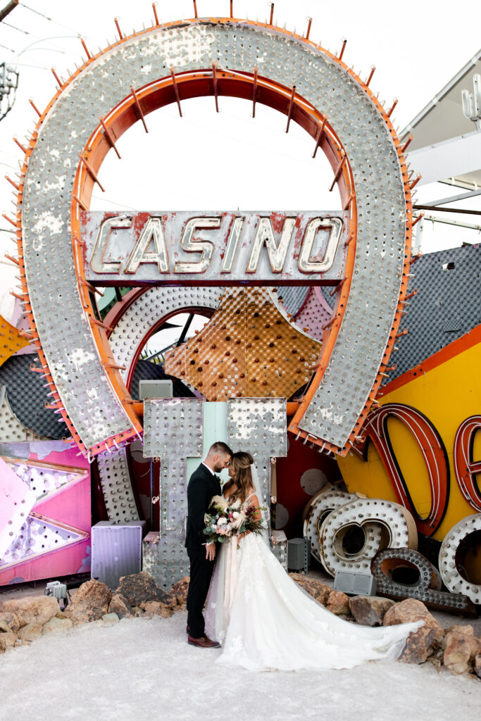 bride and groom kissing at sunset in Neon Museum