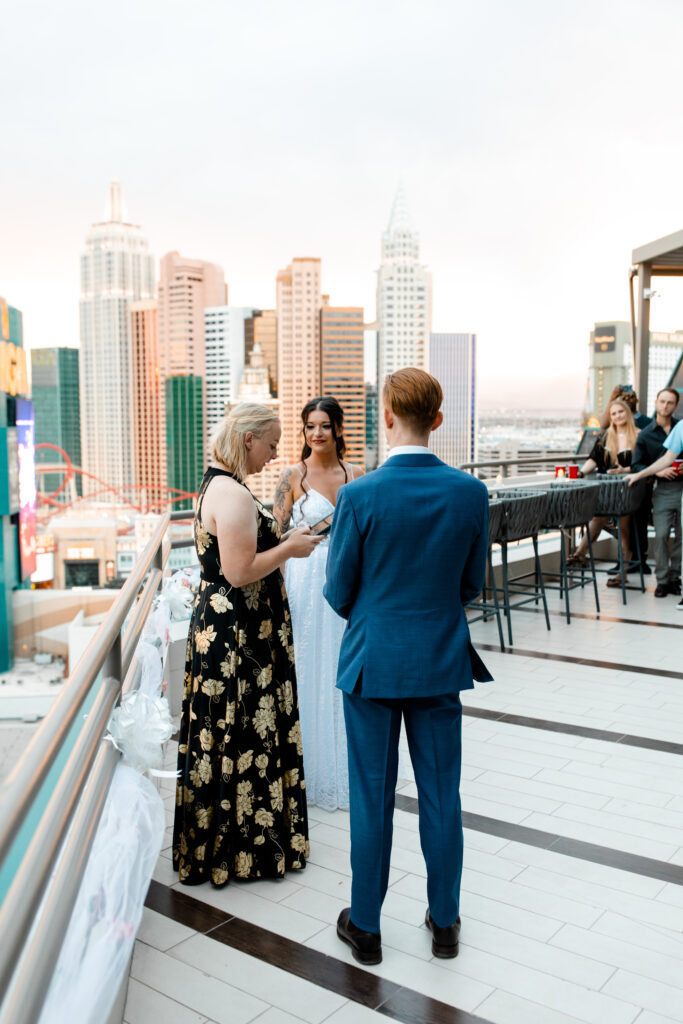 The bride and groom stand with their officiant on the terrace, moments before being pronounced husband and wife.