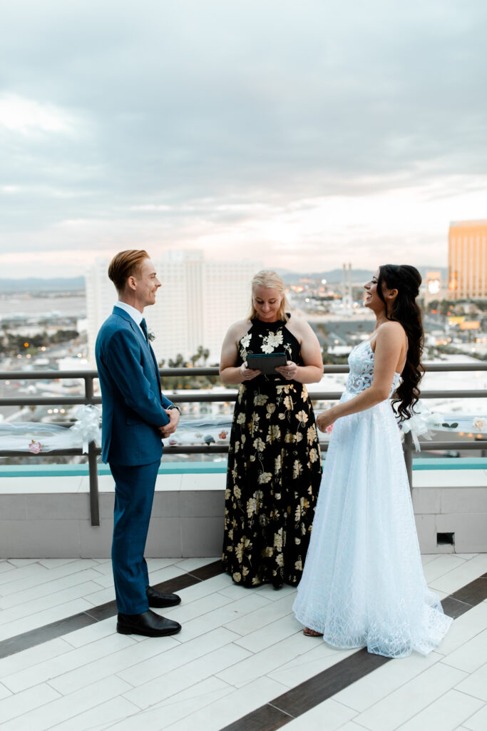 The bride and groom exchange vows during an intimate ceremony on the terrace, with the iconic skyline of Las Vegas in the background.