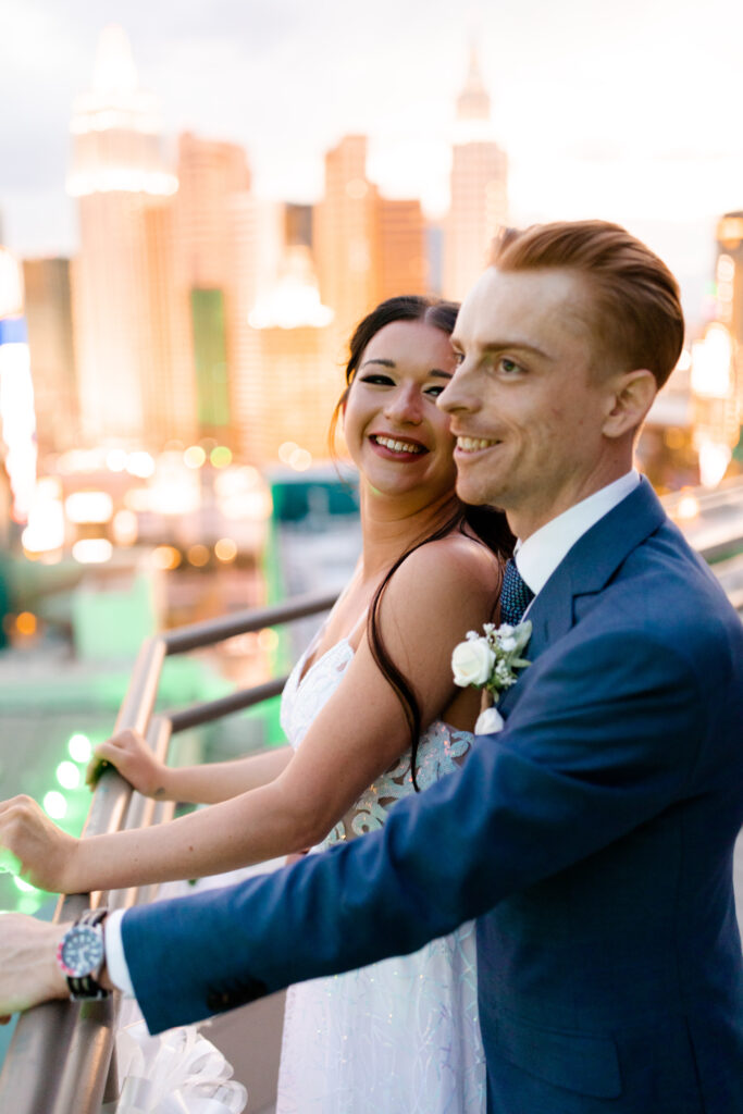 The bride and groom pose for a portrait on the terrace, with the luxurious backdrop of the MGM Grand and Las Vegas cityscape.