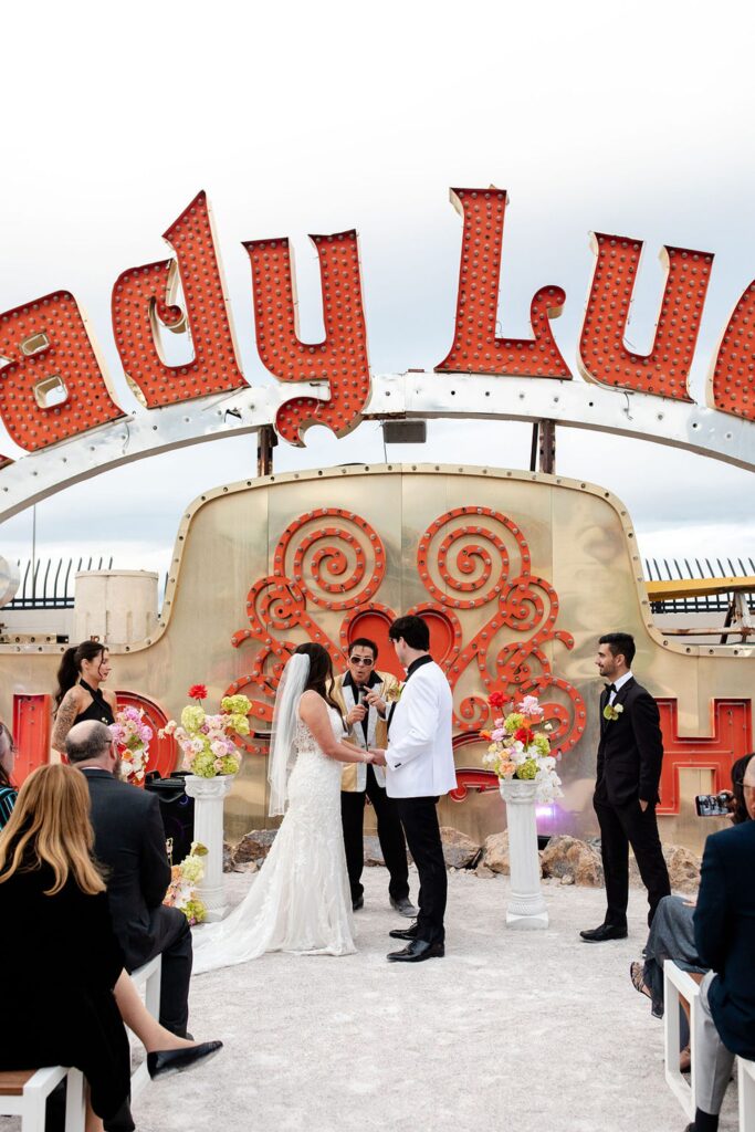 Bride and grooms Neon Museum wedding ceremony with an Elvis officiant 