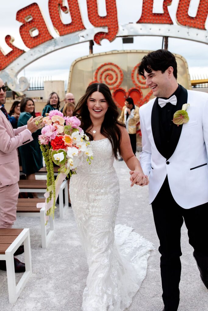 Bride and groom walking back down the aisle after their Neon Museum wedding ceremony