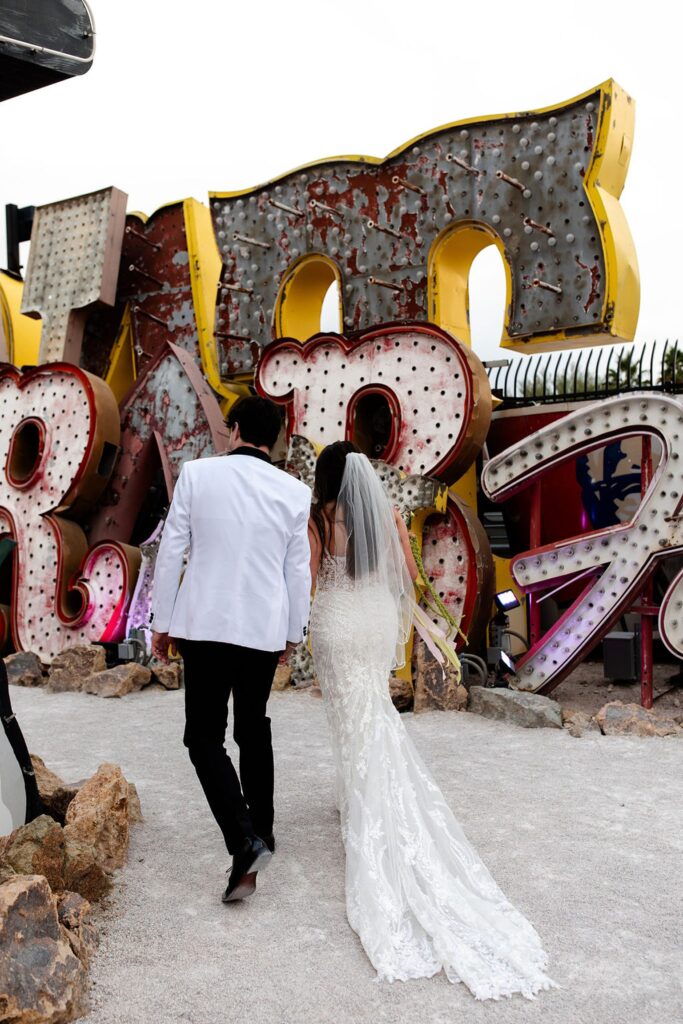 Bride and groom walking away together after their Neon Museum wedding ceremony