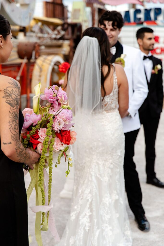 Bride and groom holding hands during their Neon Museum wedding ceremony