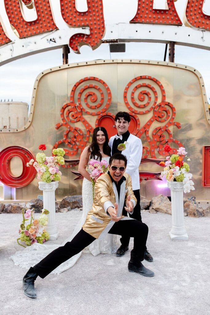 Bride and groom posing with Elvis officiant during their Neon Museum wedding photos in Las Vegas