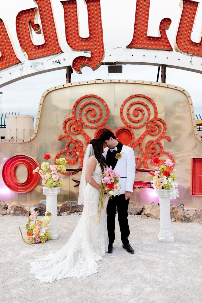 Bride and groom posing for their Neon Museum wedding photos in Las Vegas