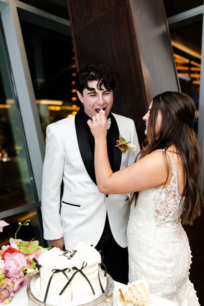 Bride and groom feeding each other cake during their indoor Las Vegas wedding reception at Maggiano's Little Italy