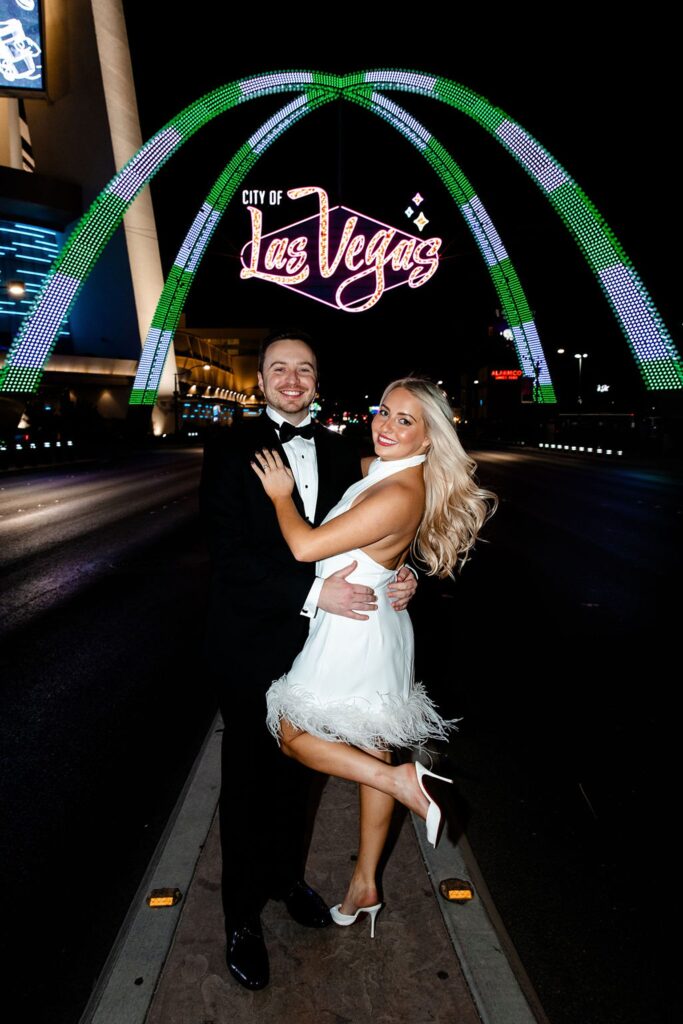 Couple posing in front of the city of Las Vegas sign for their engagement