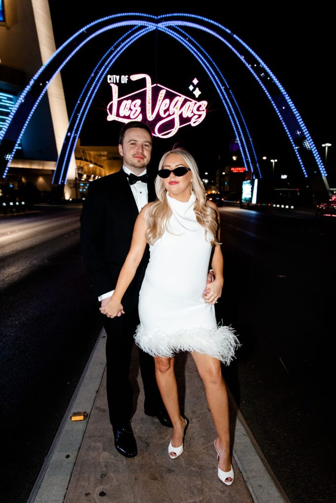 Couple posing for their engagement photos in Las Vegas in front of the city of Las Vegas sign