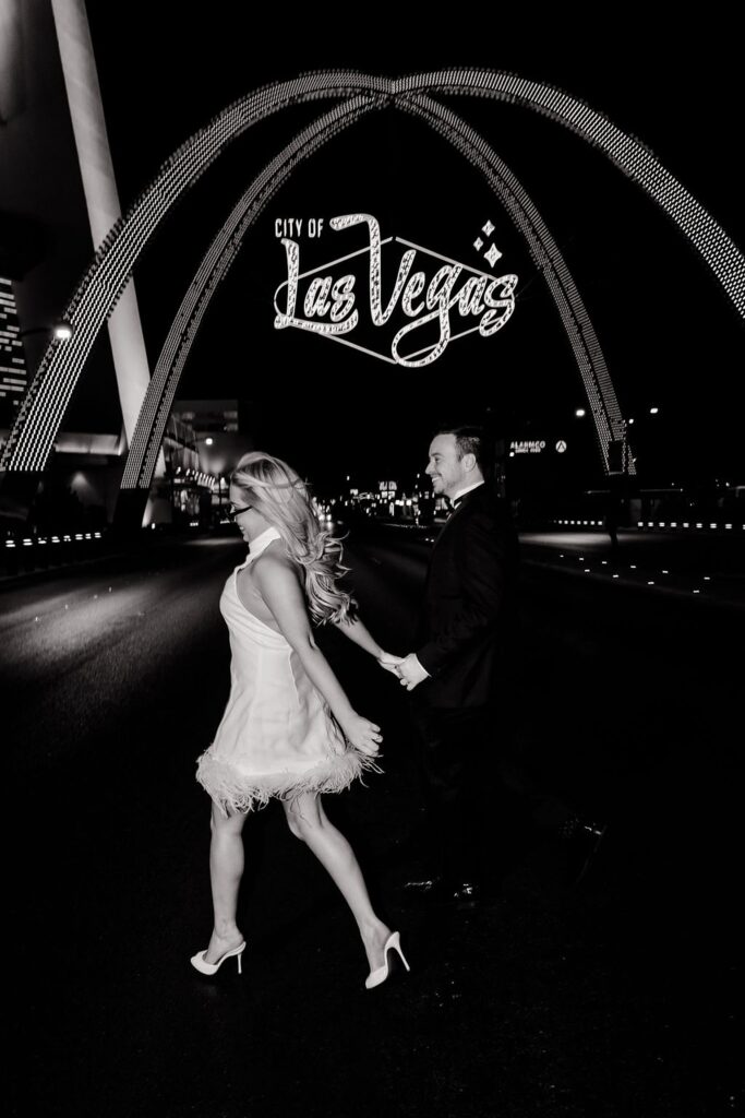 Black and white downtown engagement photos in Las Vegas un front of the city of Las Vegas sign