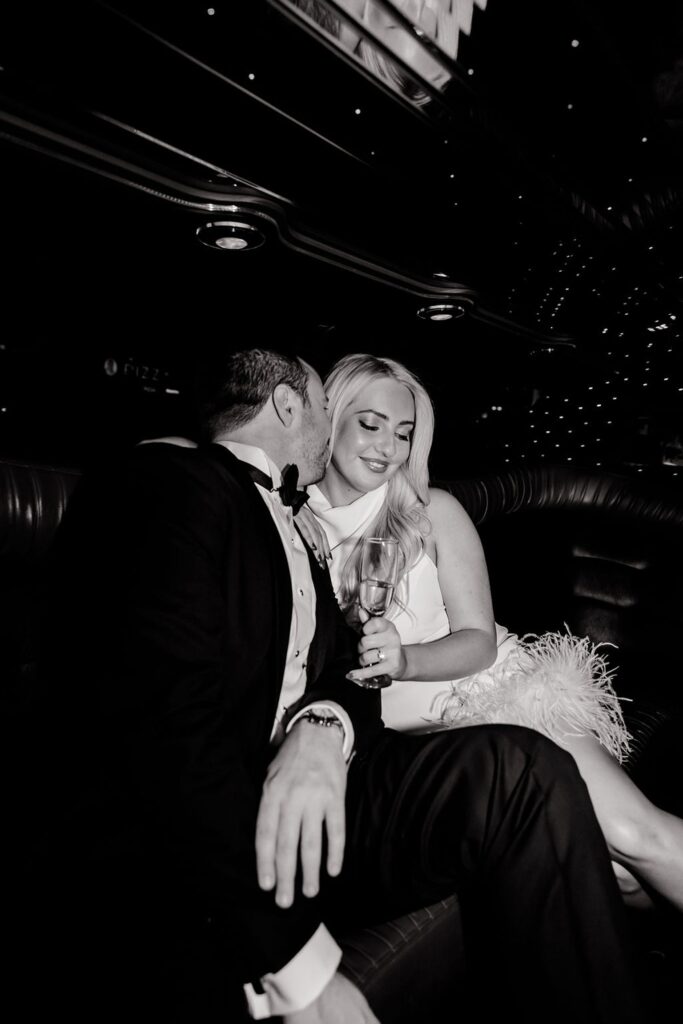 Black and white photo of a couple sitting in a limo for their engagement shoot