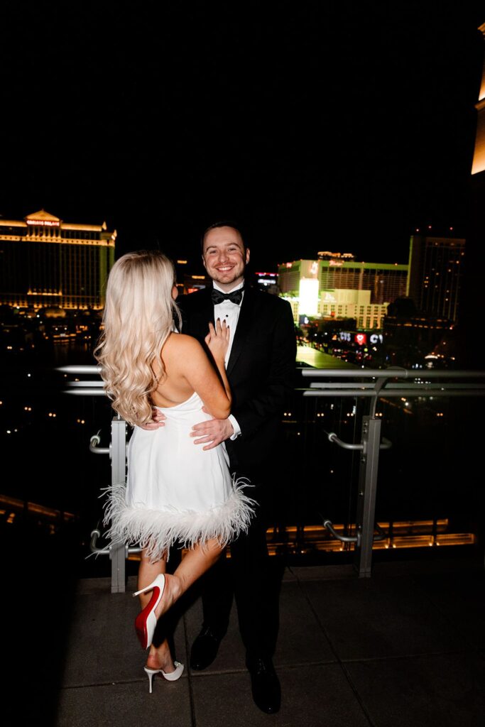 Couple posing on their hotel balcony at The Cosmopolitan for their engagement photos in Las Vegas