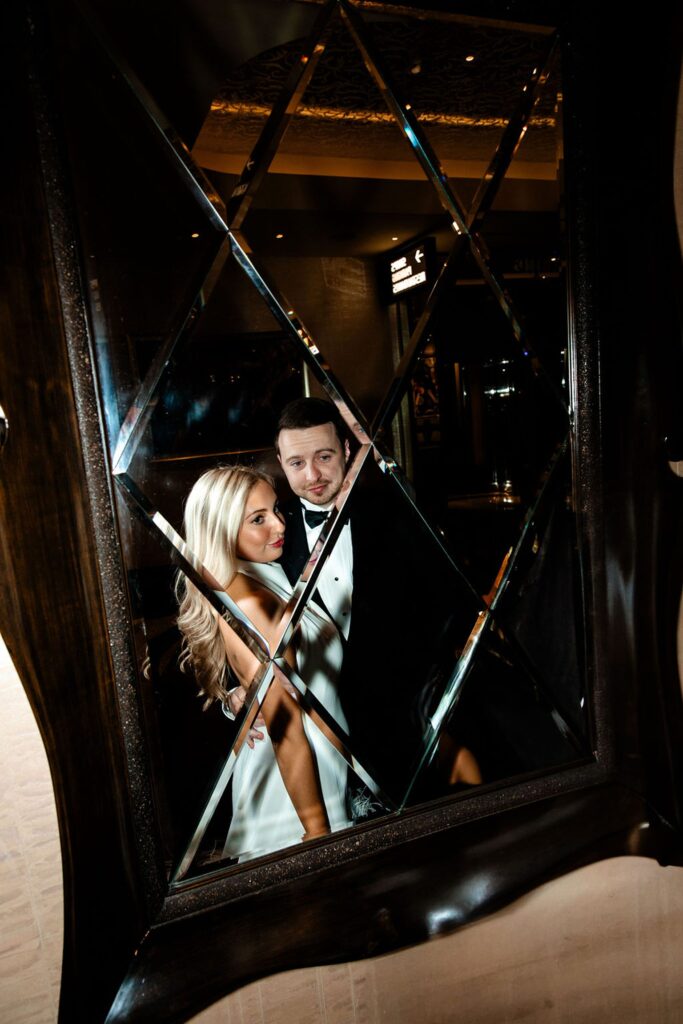 Couple posing in a mirror for their hotel engagement photos in Las Vegas