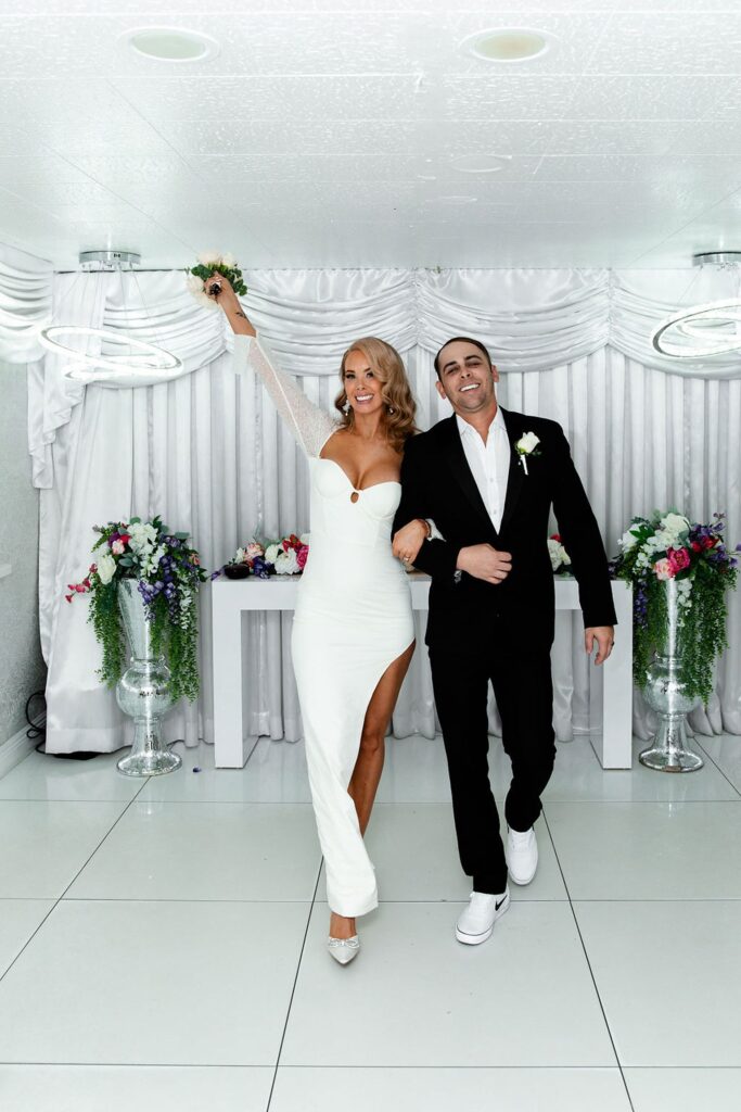 Bride and groom walking back down the aisle as husband and wife after their Little White Wedding Chapel elopement ceremony