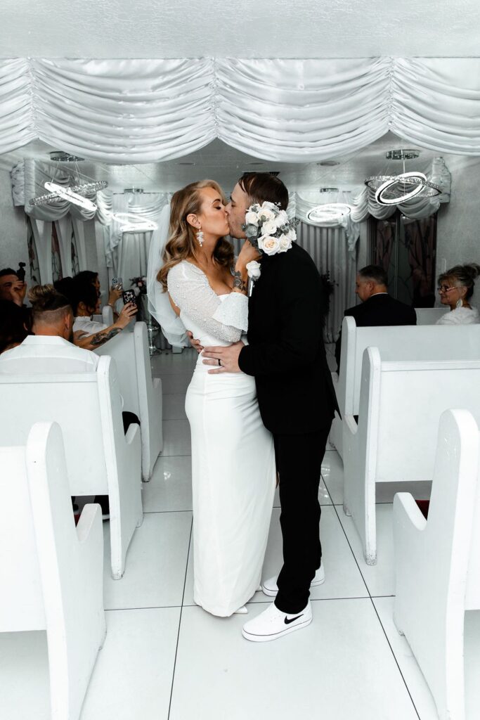 Bride and groom kissing at the end of the aisle after their Little White Wedding Chapel elopement ceremony