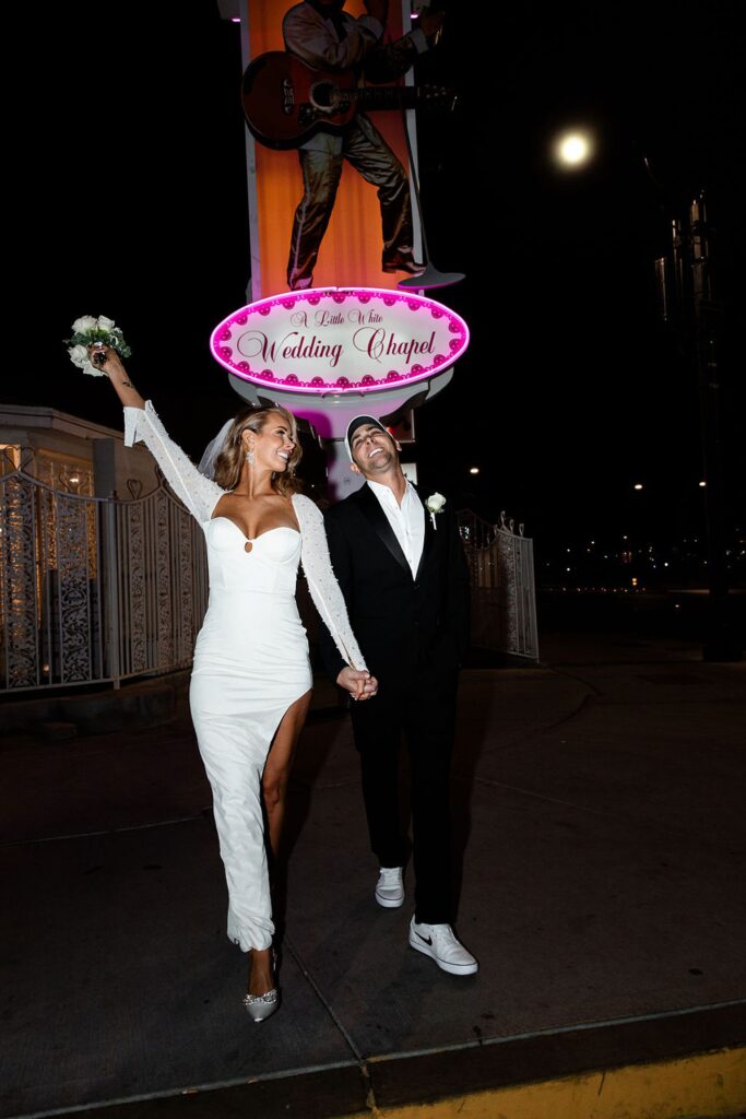 Couple posing after their Little White Wedding Chapel elopement at night