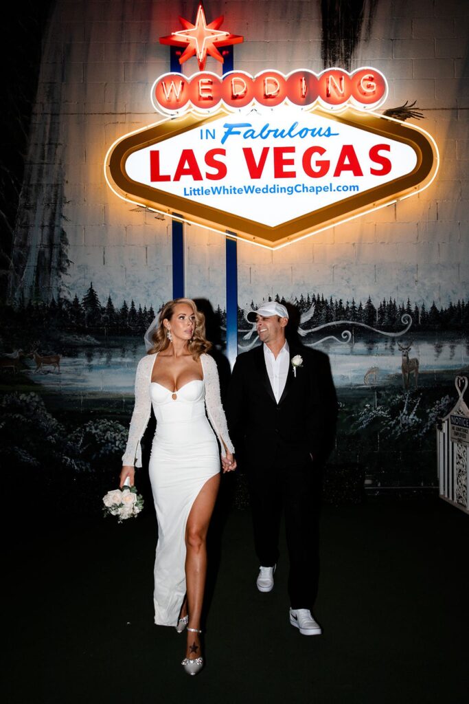 Bride and groom posing with the fabulous Las Vegas sign at The Little White Wedding Chapel Las Vegas NV