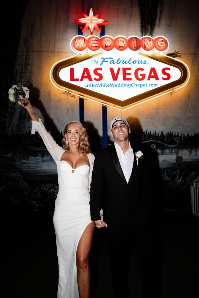 Bride and groom posing with the fabulous Las Vegas sign at The Little White Wedding Chapel Las Vegas NV