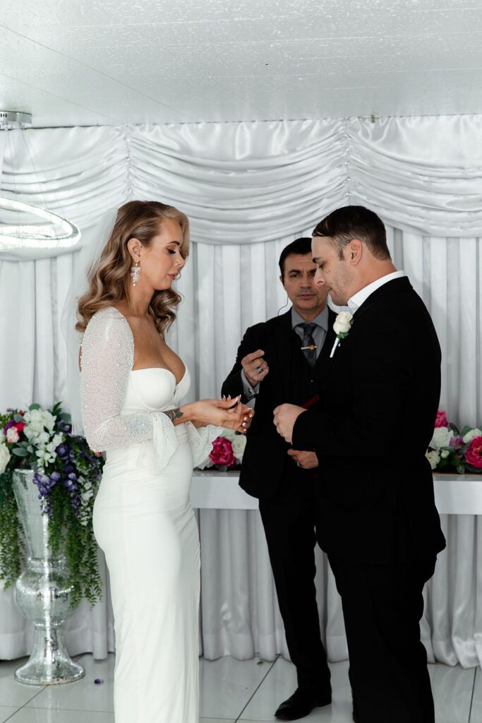 Bride and groom exchanging rings during their Little White Wedding Chapel elopement ceremony