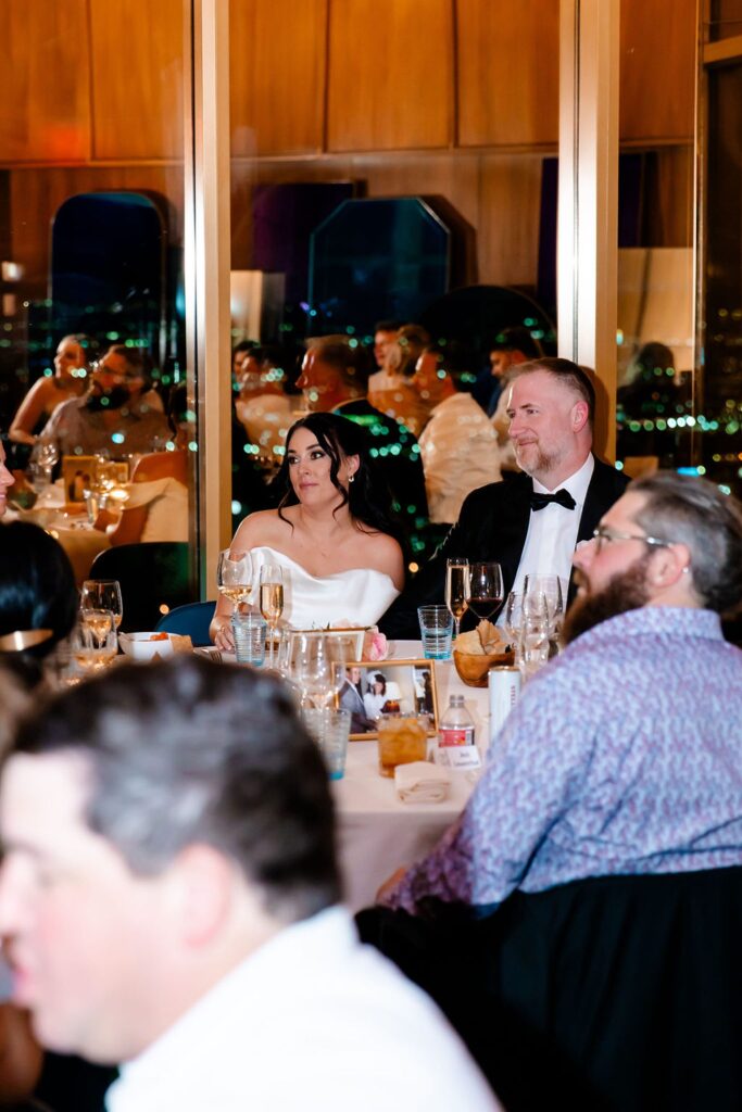 Bride and groom listening to speeches during the reception
