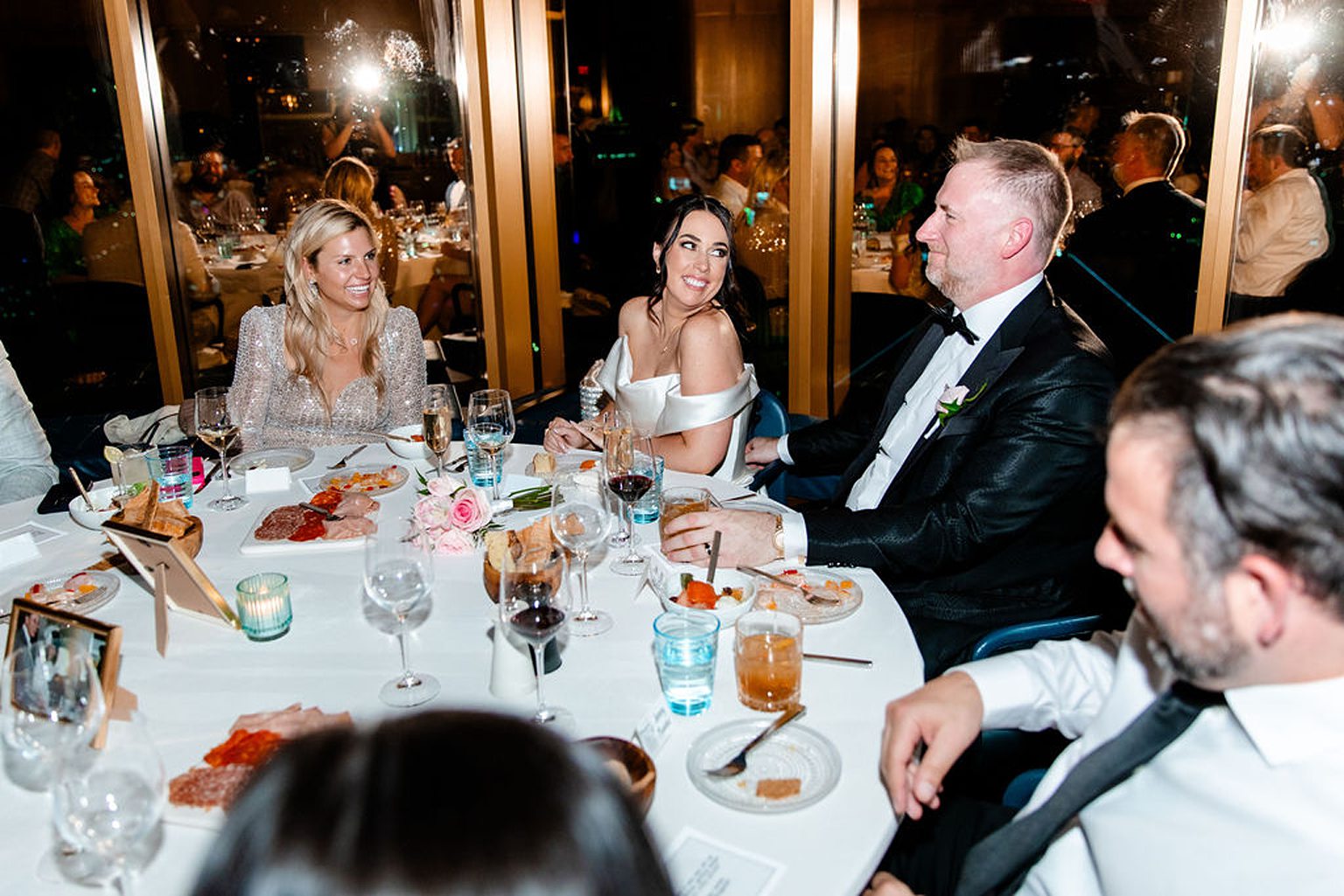 Bride and groom smiling during wedding speeches