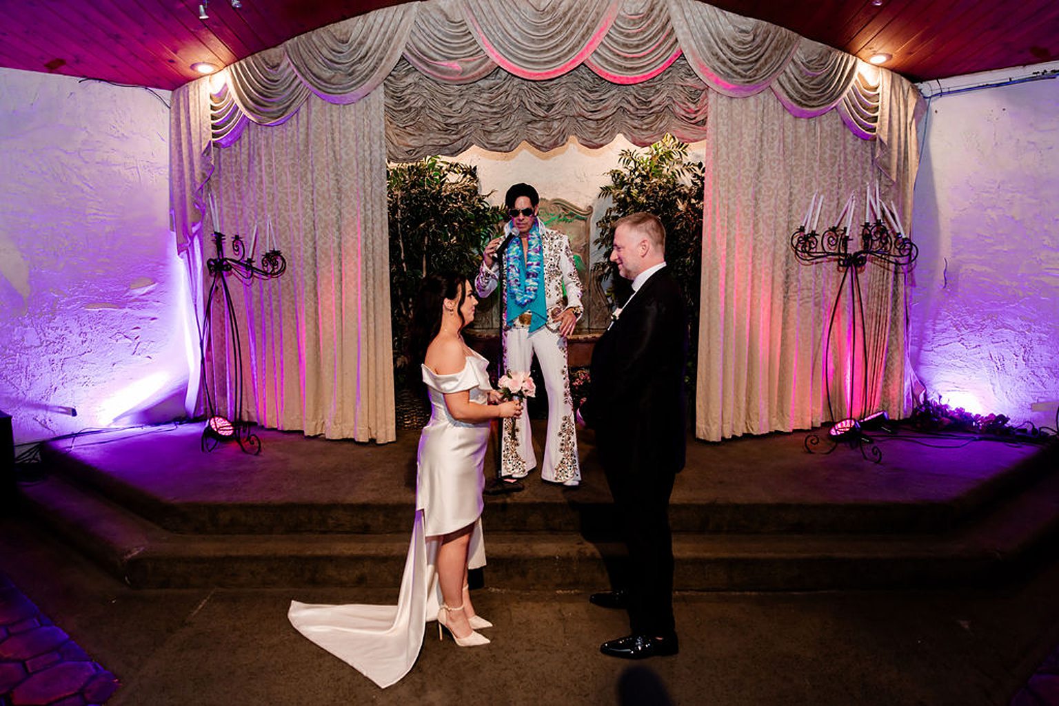 Bride and groom standing at the alter during their Las Vegas Elvis wedding ceremony at Viva Las Vegas Wedding Chapel