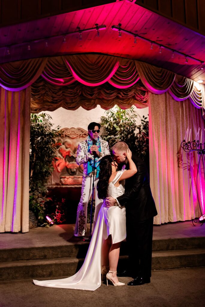 Bride and groom kissing during their Elvis Viva Las Vegas wedding ceremony