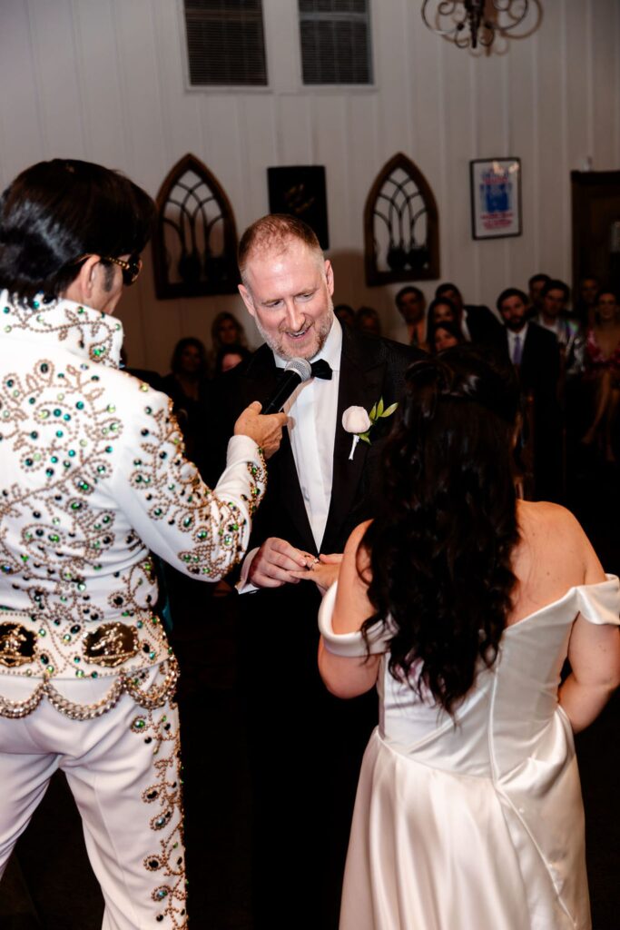 Bride and groom exchanging rings during their Viva Las Vegas wedding ceremony