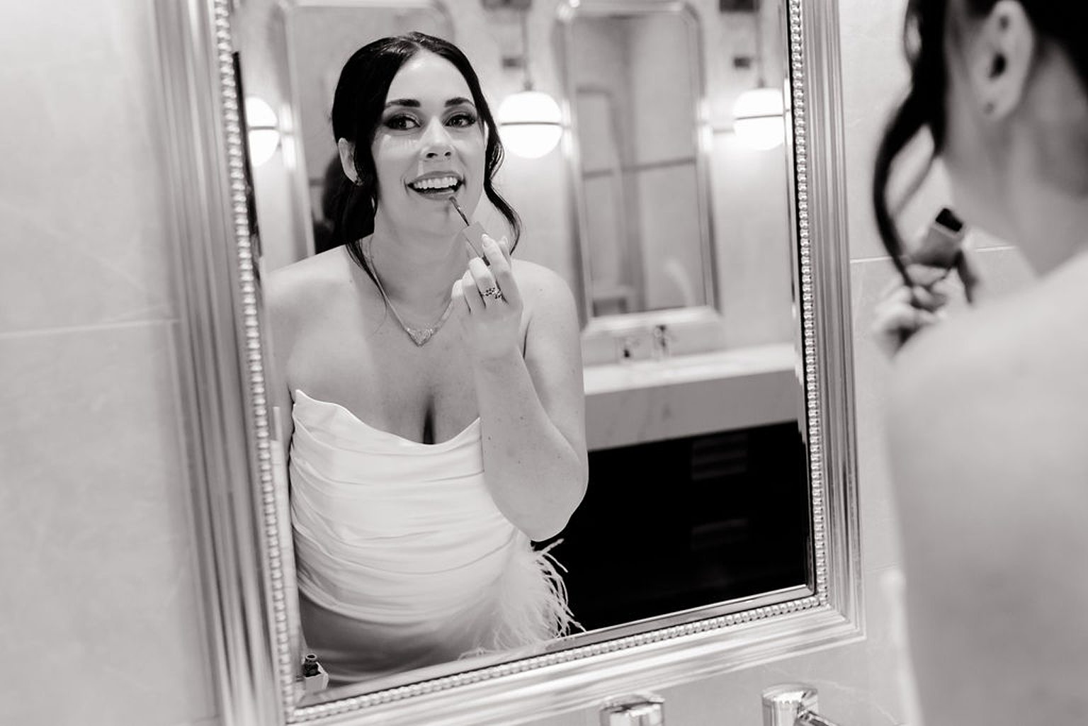 Bride putting makeup on in the mirror