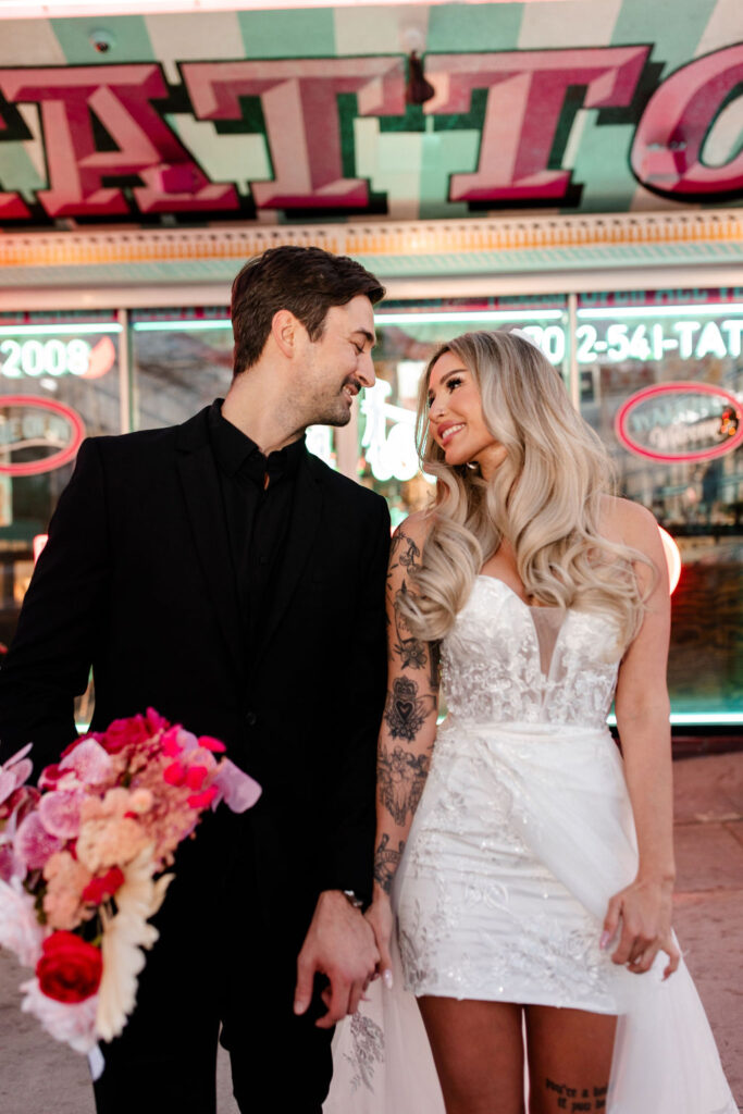 Couple smiling at each other in front of Downtown Tattoo on Fremont Street