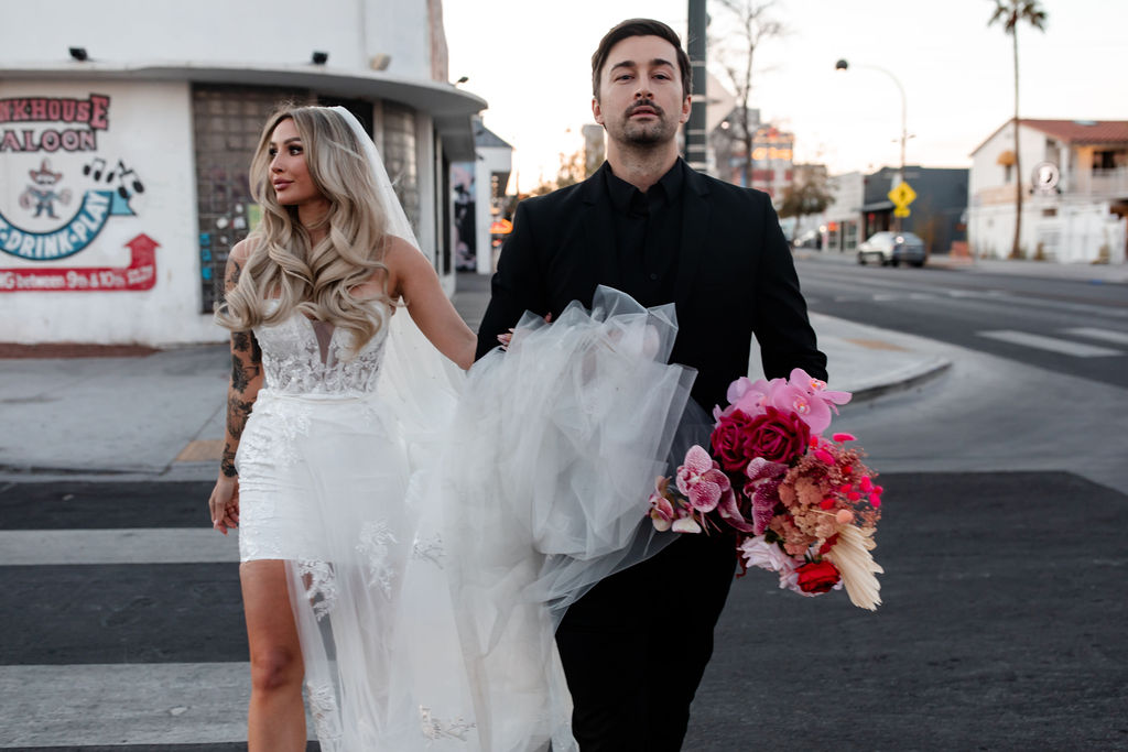 Couple holding hands and walking across the street for their downtown vintage Las Vegas wedding photos
